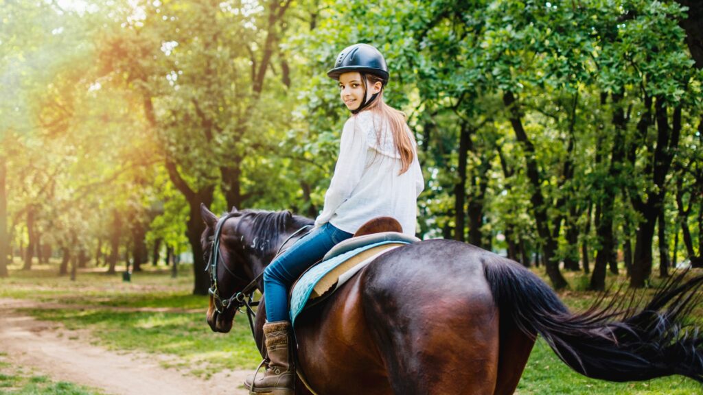 girl enjoying easy horse ride in woods picture id1225883989